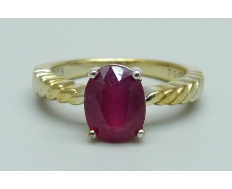 A silver gilt and ruby solitaire ring, J 