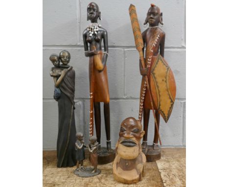 A carved hardwood tribal figure head, a pair of hardwood tribal figures with beaded decorations, height 60cms and two Soul Jo