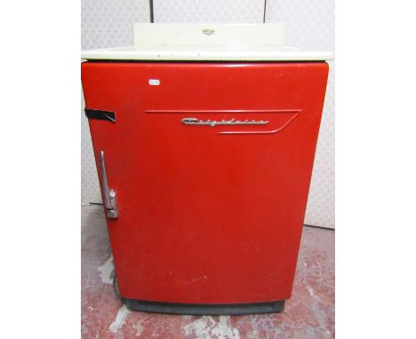 A vintage Frigidaire refrigerator, in red, with white enamel work surface 