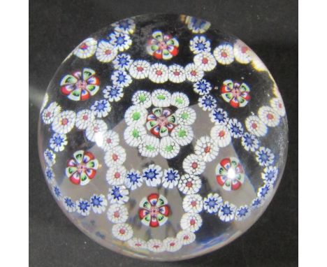 A Baccarat mid 19th century clear glass millefiori paperweight with rings of multi coloured cane and facetted stars. 
