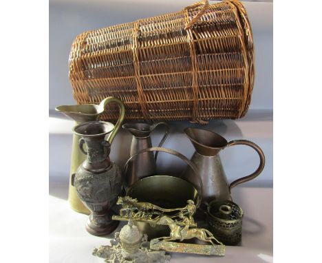 A 19th century brass and iron saucepan with a fixed handle, two copper pitchers, a brass pitcher, a cane laundry basket, a br