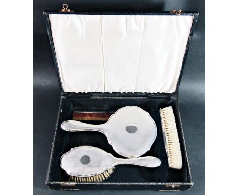 A cased set of four silver backed vanity items, comb and brush, clothes brush and mirror 