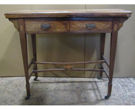 An inlaid Edwardian mahogany fold over top card table fitted with two frieze drawers raised on square tapered supports united