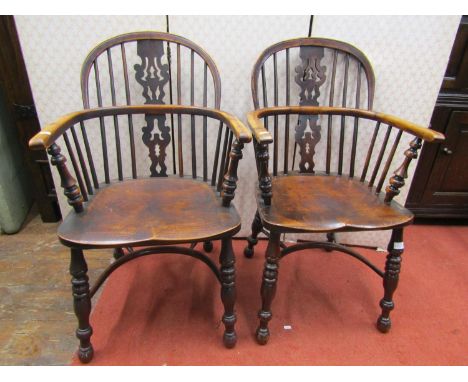 A pair of Georgian Windsor low comb back elbow chairs in elm and yew wood, with Christmas tree patterned splat 