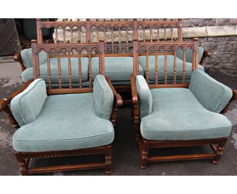 An Ercol Colonial three piece suite comprising three seat sofa and a pair of matching armchairs with turned spindle backs 