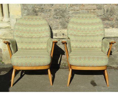 A light Ercol three seat stick-back sofa with two matching armchairs and a stool (4)