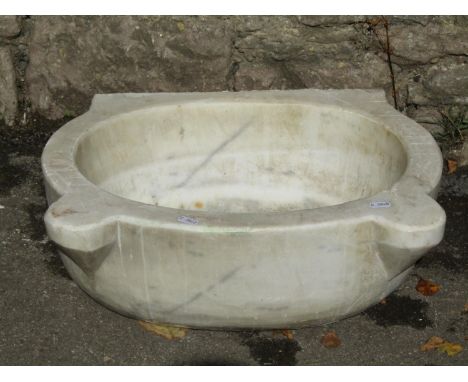 An old white marble and grey veined basin of oval form with pronounced lugs, approx 50cm wide x 40cm deep 