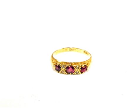 An 18ct Gold three stone Ruby set ring intersected by four Diamonds, size K