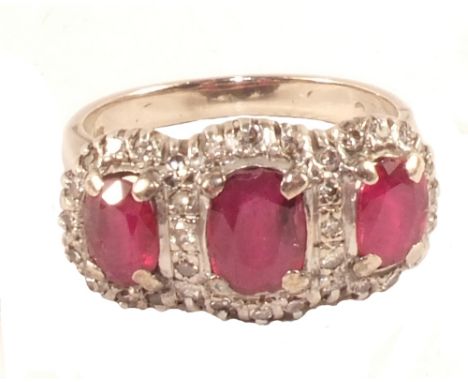 A 14ct Gold three stone Ruby ring with Diamond border