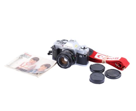 A Canon AL-1 35mm SLR camera. Chrome. Serial number 1115788. With a Canon FD 50mm f1.8 lens, caps, strap and instruction manu