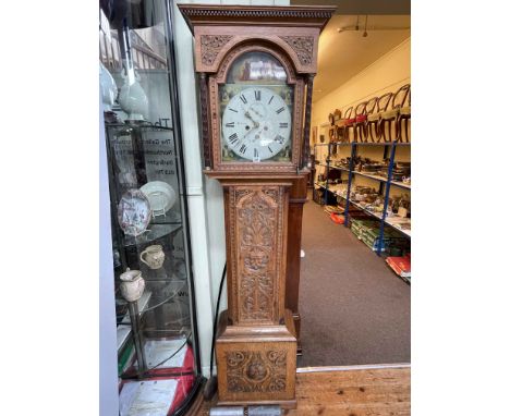 Antique carved oak eight day longcase clock having painted arched dial, 209cm.