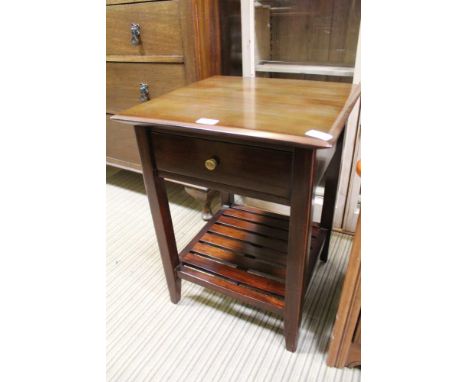 A MAHOGANY FINISHED SQUARE TOPPED LAMP TABLE fitted with a single drawer, with a slatted magazine undertier 