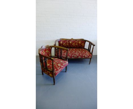 A two part parlour suite having a mahogany and inlaid frame two seater sofa and tub chair upholstered in deep red and gold  f