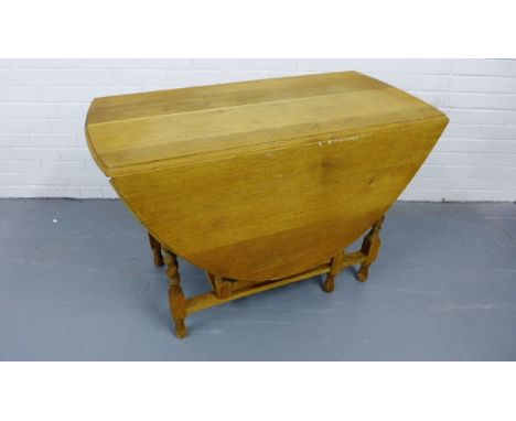 A striped oak gate leg table having a moulded top over barley twist supports, raised on bun feet, 107 x 73cm 