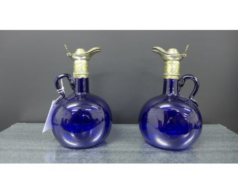 A pair of blue glass decanter jugs each with loop handle to side and with Epns collar and lid (2)