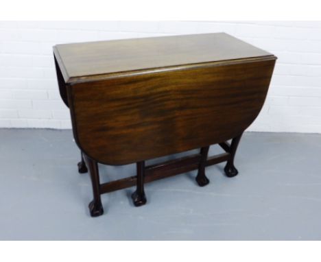 A mahogany gate leg table having a moulded top raised on turned supports and ball and claw feet