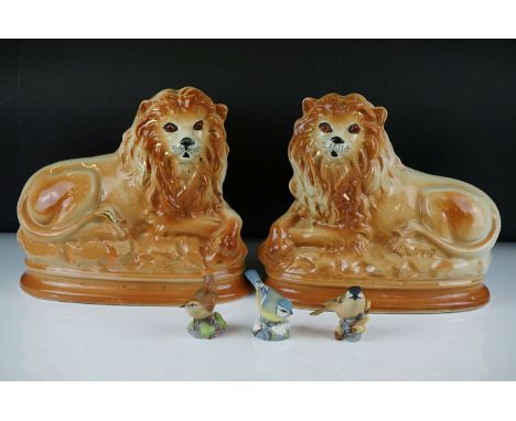 Pair of Staffordshire seated lions with glass eyes, approx 27cm wide, together with three Royal Worcester bone china bird fig