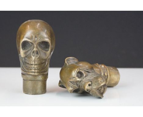 Two brass walking stick handles to include a skull and a bulldog example. 