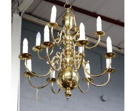 A pair of reproduction Dutch style brass twelve light chandeliers, with scrolled branches, arranged in two rows, 84cm high.