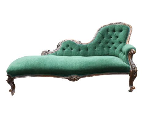 A Victorian foliate carved walnut frame chaise longue, circa 1860, having a scrolled, shaped and curved button down upholster