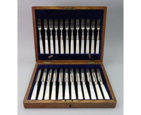 An oak cased set of twelve pairs of fruit knives and forks, makers mark J R, Sheffield 1922, with mother of pearl handles.