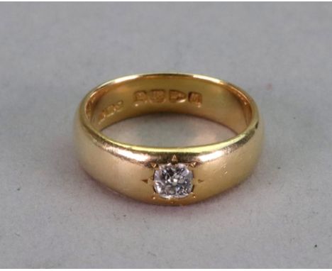 An 18ct gold and diamond single stone ring, the cushion cut diamond in star gypsy setting, to slightly tapered gold band, rin