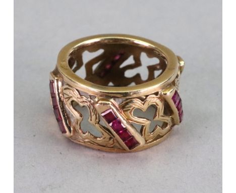 A gold and ruby ring, six rows of four step cut rubies channel set between gold openwork design, ring size P, 10.28g gross. 