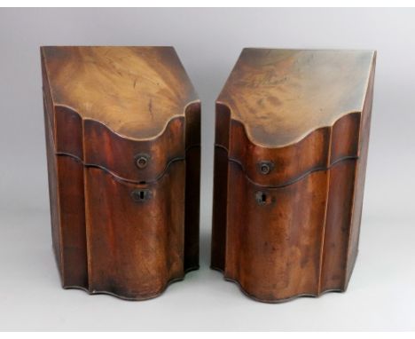 A pair of George III mahogany boxwood banded knife boxes, of serpentine outline, the sloping hinged covers enclosing fitted i