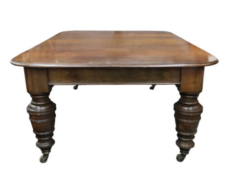 A late Victorian mahogany extending dining table, the moulded edge top with rounded corners and three extra leaves, on massiv