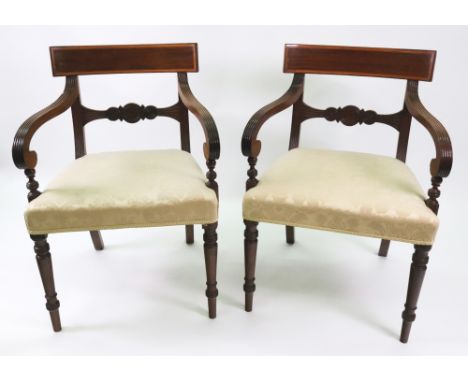 A pair of George III mahogany open arm elbow chairs, with reeded frames, satinwood crossbanded ebony strung curved top rails,