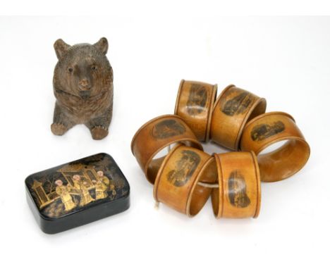 A set of six Mauchline ware napkin rings, printed with views of Shanklin and numbered 1 - 6, a Black Forest novelty inkwell, 