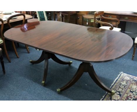 A reproduction Regency style mahogany 'D' end dining table, the reeded edge top with extra leaf, on twin vase turned columns 