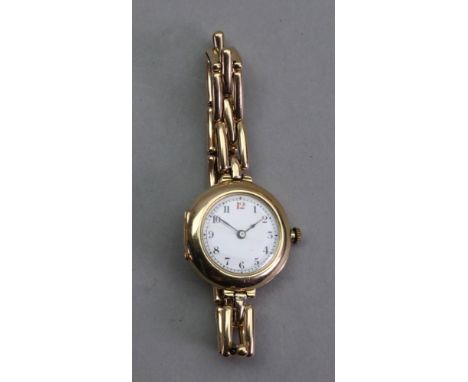 A lady's 15ct gold manual wind wristwatch, the white enamel dial with Arabic numerals, a 15 jewel movement, with a yellow met