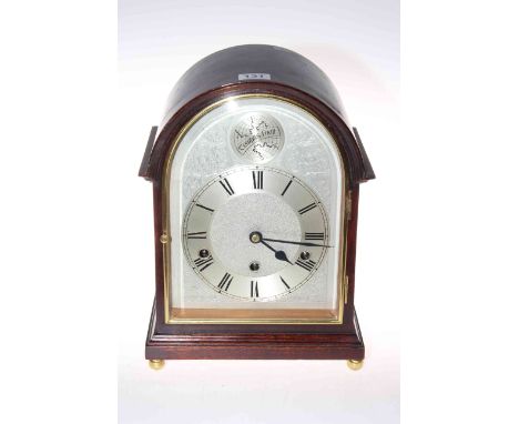Mahogany mantel clock with quarter striking movement, of arched shape and on brass ball feet, 32cm.