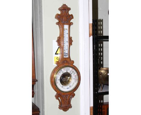 Carved oak barometer with enamelled dial.