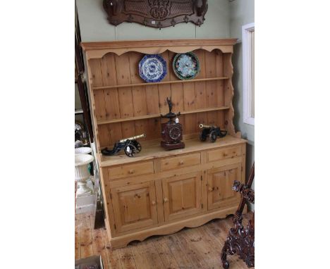 Pine dresser having shelf back above three drawers with three doors below, 191cm by 152cm.