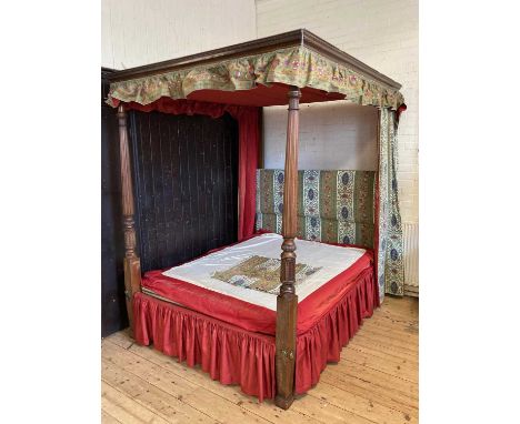 A MAHOGANY FOUR POSTER BEDSTEAD of Georgian design, 19th century, the canopy with a dentil moulded and leaf carved cornice on