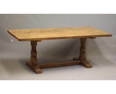 A ROBERT THOMPSON ADZED OAK DINING TABLE, the rounded oblong triple plank top raised on two baluster turned faceted legs, the