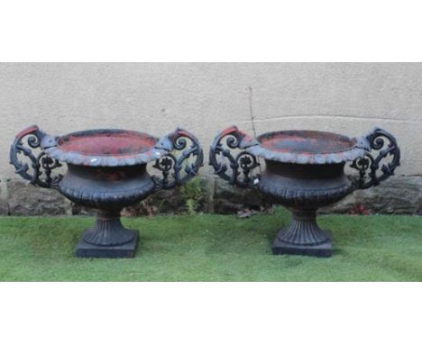 A PAIR OF CAST IRON URNS, 20th century, of semi fluted campana form with scrolled handles and ovolo moulded rim, on fluted so