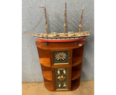 A nautical themed wall hanging shelf and a wooden display ship