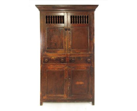 A 19th century painted pine food cupboard having two cupboard doors with spindles over two drawers above two paneled cupboard