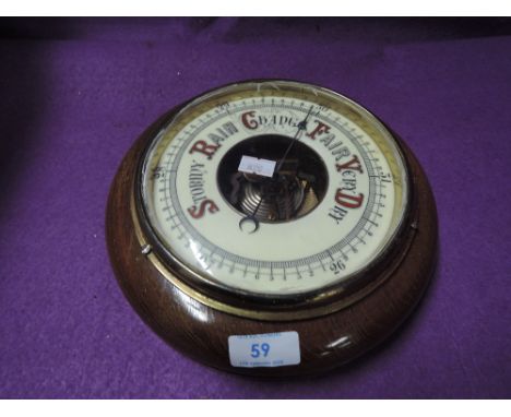 An enamel faced port hole style barometer 