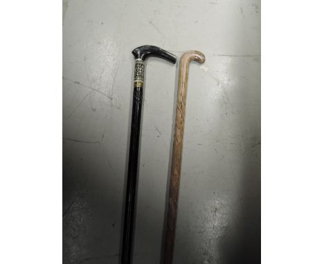 A sword stick and a carved walking stick