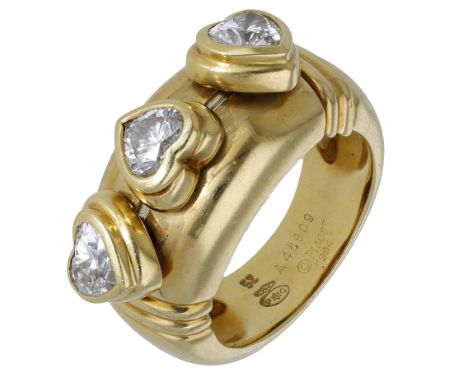 A diamond ring by Piaget, set with three sliding heart-shaped diamond collets, on a polished band with reeded detailing, sign