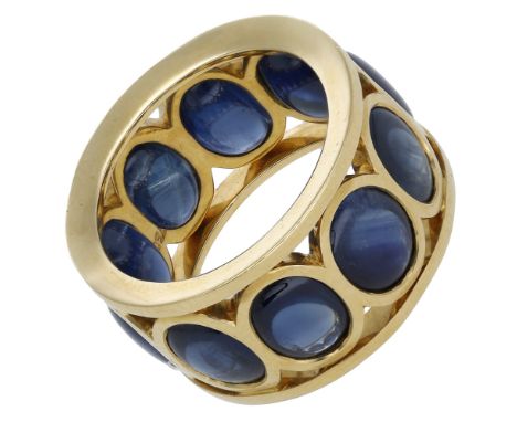 A sapphire dress ring, of openwork design, set with a continuous row of oval sapphire cabochons, stamped ‘750’, ring size L. 