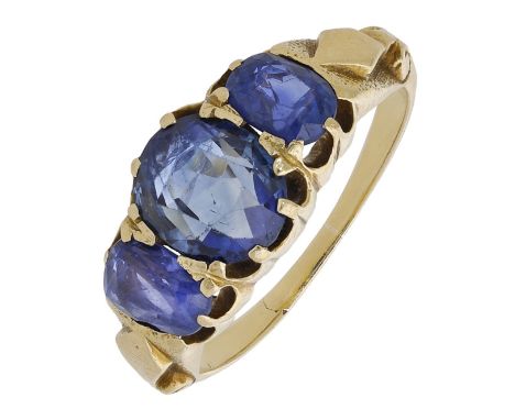 A Sri Lankan three stone sapphire ring, the oval-cut stones in claw mounts, between textured and lozenge decorated shoulders,