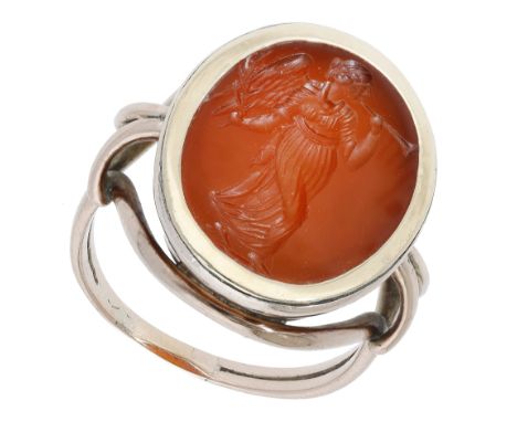 A 19th century hardstone intaglio ring, the carnelian panel carved to depict an annunciatory angel holding an olive branch, g