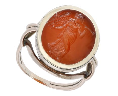 A 19th century hardstone intaglio ring, the carnelian panel carved to depict an annunciatory angel holding an olive branch, g