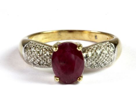 A 9ct yellow gold ring set with an oval cut ruby and diamond set shoulders, (M.5).