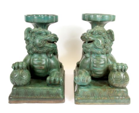 A pair of large Chinese green glazed ceramic lion dog figures holding cornucopia, H. 25cm.